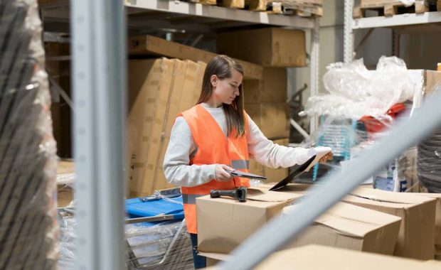 Mujer en almacén escaneando pedidos para hacer el picking en retail
